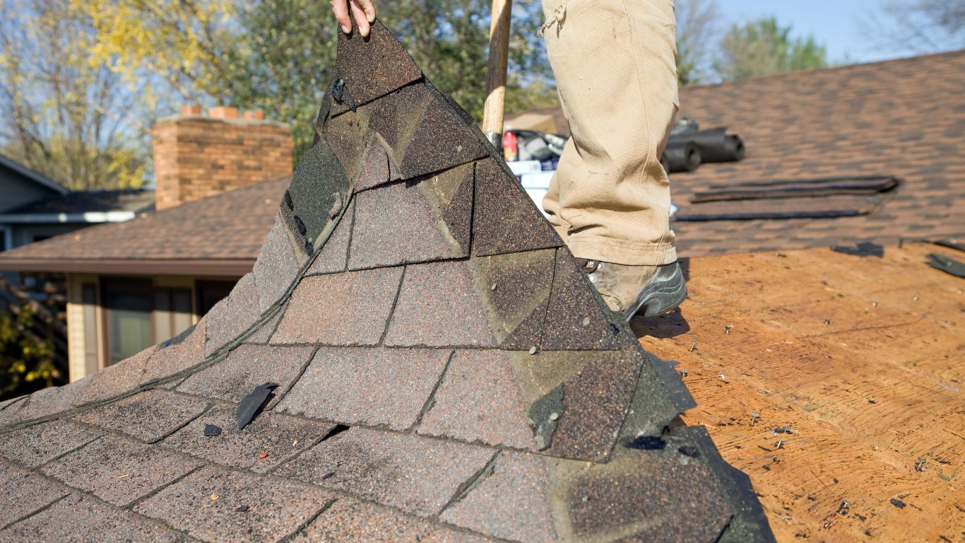 Roof replacement in progress with old roofing materials being removed