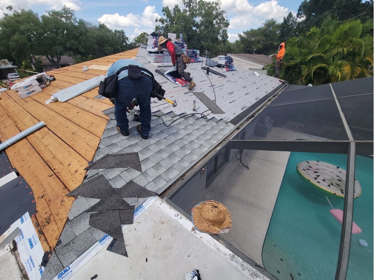 Roofing crew installing shingles on a residential roof in New Port Richey, Florida